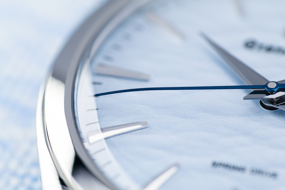 Thermally-blued, curved seconds hand.