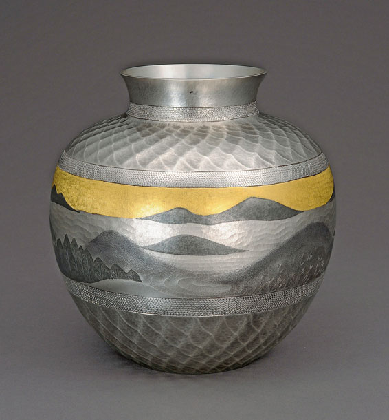 An ornamental metal vase with hammered details depicting a natural scene, done via tankin.